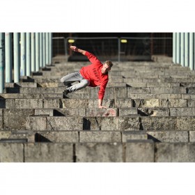 A young man in a red sweatshirt performing parkour on stone blocks in an urban settin, captured with Nikon Z 400mm f/4.5 VR S A young man in a red sweatshirt performing parkour on stone blocks in an urban settin, captured with Nikon Z 400mm f/4.5 VR S