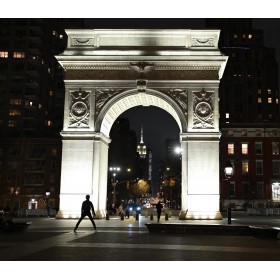 Una persona caminando bajo un arco iluminado en una noche urbana, capturado con Nikon Z 35mm f/1.4 Una persona caminando bajo un arco iluminado en una noche urbana, capturado con Nikon Z 35mm f/1.4