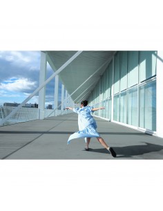A woman in a flowing blue dress spins joyfully on a modern balcony under a cloud, captured with Canon RF 16-28mm f/2.8 IS STM A woman in a flowing blue dress spins joyfully on a modern balcony under a cloud, captured with Canon RF 16-28mm f/2.8 IS STM
