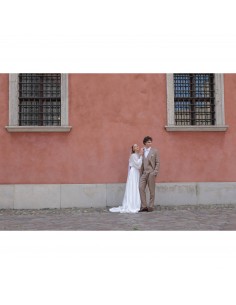 Pareja posando frente a pared rosa, vestido de novia y traje elegante, luz natural, capturado con Canon RF 50mm f/1.4 L VCM Pareja posando frente a pared rosa, vestido de novia y traje elegante, luz natural, capturado con Canon RF 50mm f/1.4 L VCM
