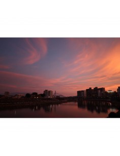 Atardecer sobre un río con edificios al fondo y nubes coloridas, capturado con Canon RF 24mm f/1.4 L VCM Atardecer sobre un río con edificios al fondo y nubes coloridas, capturado con Canon RF 24mm f/1.4 L VCM