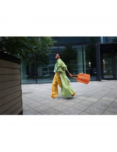 Mujer con abrigo verde y pantalones amarillos camina con bolso naranja en un entorno, capturado con Canon RF 24mm f/1.4 L VCM Mujer con abrigo verde y pantalones amarillos camina con bolso naranja en un entorno, capturado con Canon RF 24mm f/1.4 L VCM