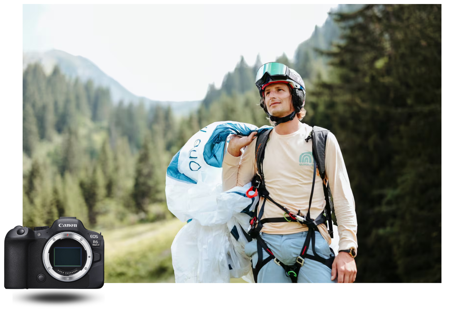 Portrait lumineux réalisé avec le Canon EOS R6 II d’un parapentiste portant sa voile devant une forêt de montagne Portrait lumineux réalisé avec le Canon EOS R6 II d’un parapentiste portant sa voile devant une forêt de montagne
