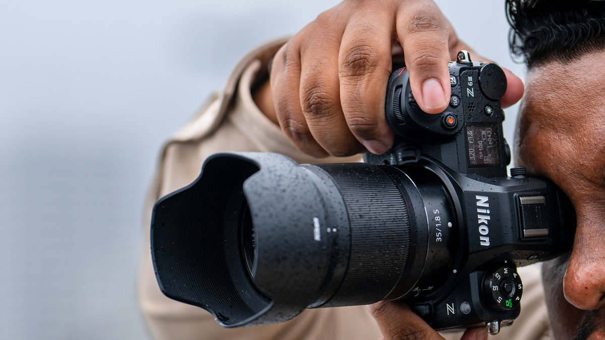 Photographer using a Nikon Z6III in light rain during an outdoor shoot